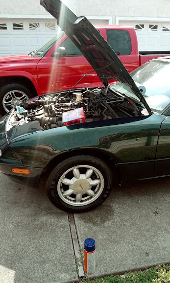 Green Mazda Miata with the hood up