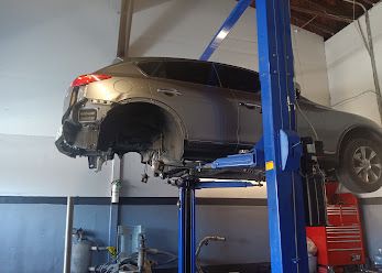 SUV raised on a lift with a rear wheel removed